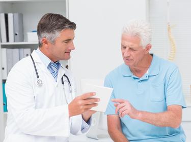A doctor explains medication to an older male patient