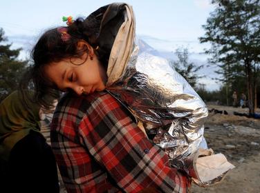 A Syrian refugee carries his sleeping daughter as they walk toward Greece's border with Macedonia, September 14, 2015