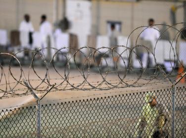 A Navy guard patrols Camp Delta's detainee recreation yard during the early morning at Guant&aacute;namo Bay naval base on July 7, 2010