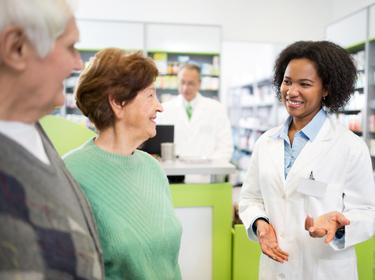 An older couple talking with a pharmacist