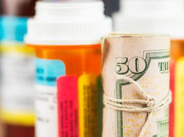 U.S. currency wrapped around prescription bottle