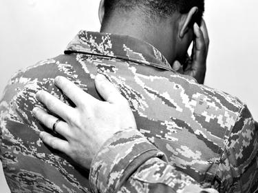 A U.S. Air Force Airman places his hand on another Airman's back at Shaw Air Force Base, S.C., November 21, 2014