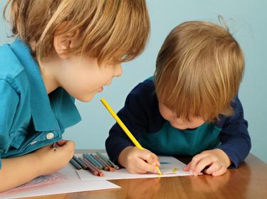 two preschool children using colored pencils
