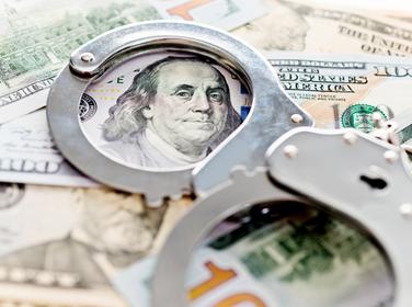 Handcuffs lying on $100 bills
