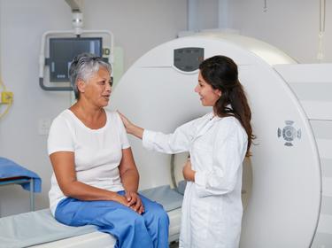 A woman on an MRI machine talking to her doctor