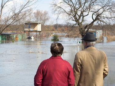 Older man and woman surveying flood damage