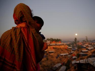 A Rohingya refugee looks at the moon with a child in tow at Balukhali refugee camp, Bangladesh, December 3, 2017