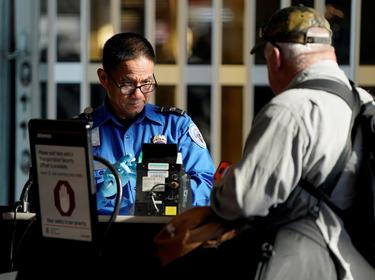 A TSA employee checks the documents of a traveler at Reagan National Airport in Washington, D.C., January 6, 2019