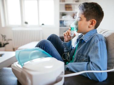 Boy using breathing treatment, photo by mixetto/Getty Images