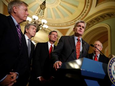 Sen. Bill Cassidy (R-LA), accompanied by Sen. Lindsey Graham (R-SC), Sen. Roy Blunt (R-MO), Sen. John Barrasso (R-WY) and Senate Majority Leader Mitch McConnell, speaks with reporters following the party luncheons on Capitol Hill in Washington, U.S., September 19, 2017.