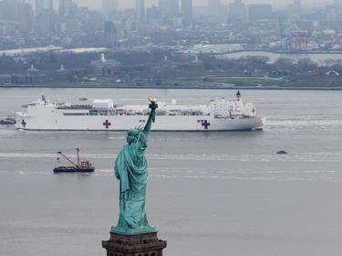 The U.S. Navy hospital ship Comfort passes the Statue of Liberty as it enters New York Harbor during the COVID-19 outbreak, March 30, 2020, photo by Mike Segar/Reuters
