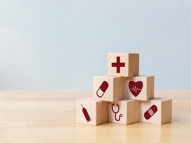 Wood block stacking with icon healthcare medical, Insurance for your health concept, photo by marchmeena29/Getty Images