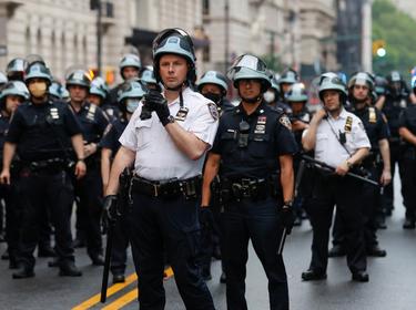 Police officers stand guard across Central Park West during a protest against the death in Minneapolis police custody of George Floyd, in New York City, June 5, 2020, photo by Mike Segar/Reuters