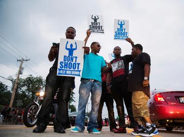 Demonstrators gesture and chant as they continue to react to the shooting of Michael Brown in Ferguson, Missouri August 17, 2014
