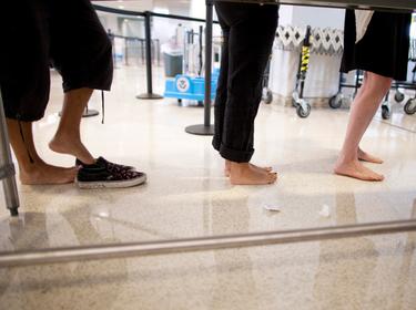Fliers take off their shoes before going through a TSA security checkpoint in the Newark Liberty International Airport in Newark, New Jersey, July 28, 2011, photo by Lucas Jackson/Reuters