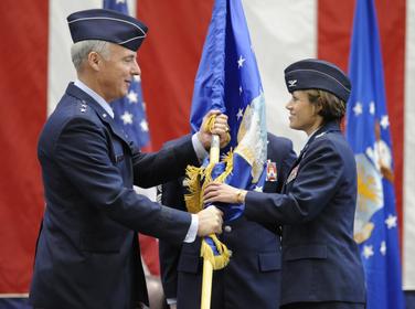 Maj. Gen. Winfield Scott III, 18th Air Force commander, passes the wing flag to Col. Gina Grosso, the new 87th Air Base Wing commander, during an assumption of command ceremony here March 3. Colonel Grosso will be the first joint base commander of JB McGuire-Dix-Lakehurst