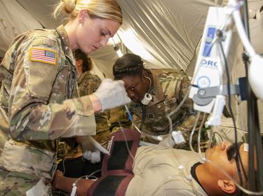 Capt. Tara Brouse, critical care nurse, intensive care unit, Madigan Army Medical Center, assists with treating a mock patient at the Internal Care Ward of the 131st Field Hospital, 528th Hospital Center, photo by U.S. Army