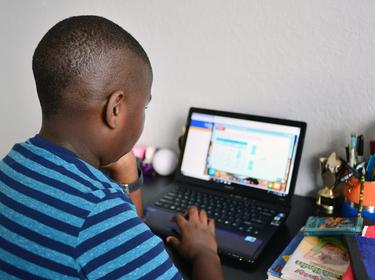 Nine year old student Jordan in his bedroom attending online school in Broward County, Florida, March 31, 2020, photo by Johnny Louis/Reuters