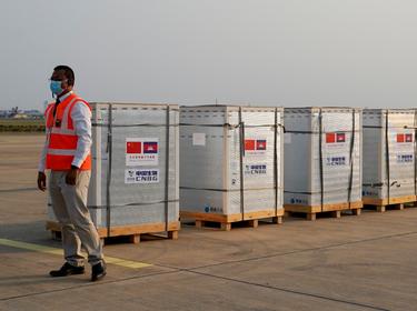 A worker stands next to the shipment of 600,000 doses COVID-19 vaccines donated by China at the Phnom Penh International Airport, in Phnom Penh, Cambodia, February 7, 2021, photo by Cindy Liu/Reuters