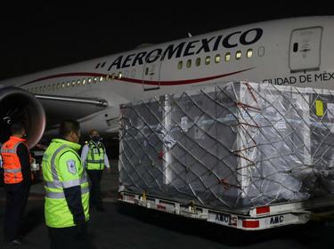 Workers stand near the first shipment of the AstraZeneca COVID-19 vaccine delivered under the COVAX scheme, at Benito Juarez's International Airport in Mexico City, Mexico, April 22, 2021, photo by Henry Romero/Reuters