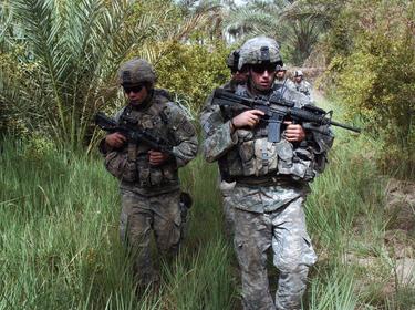 U.S. Army soldiers patrol through a palm grove looking for insurgents and weapons caches during an operation in the Diyala River Valley region of Iraq on Aug. 18, 2007, Photo by Sgt 1ST Class Robert C Brogan/U.S. Army