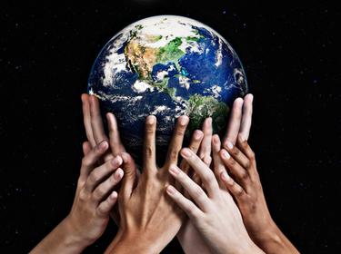 Hands holding up a globe, photo by RapidEye/Getty Images