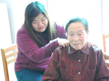 Younger woman gives a Korean senior a shoulder massage at the House of Wusula, in Yangseong-myeon, Anseoung-si, on 2 February 2013, photo by Tanya Im, U.S. Army/CC BY 2.0
