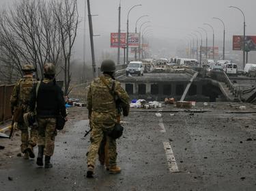 Ukrainian servicemen stand by a destroyed bridge as Russia's invasion of Ukraine continues, in the town of Irpin outside Kyiv, Ukraine, April 1, 2022, photo by Gleb Garanich/Reuters