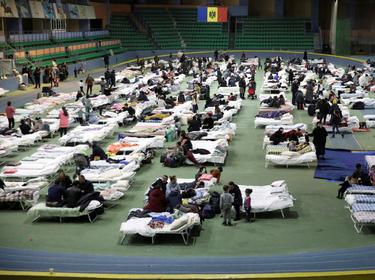 People fleeing Russia's invasion of Ukraine rest in a temporary refugee center located at a local track-and-field athletics stadium in Chisinau, Moldova, March 4, 2022, photo by Vladislav Culiomza/Reuters
