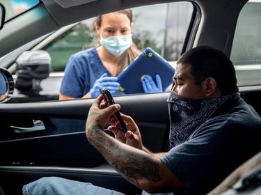 Joe Garcia waits to get tested in his car for COVID-19 in Austin, Texas, June 28, 2020, photo by Sergio Flores/Reuters