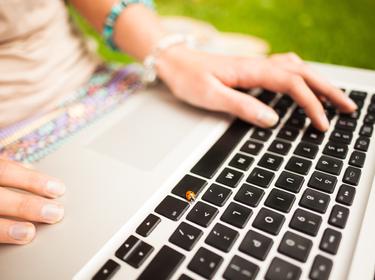 Close up of young woman using laptop