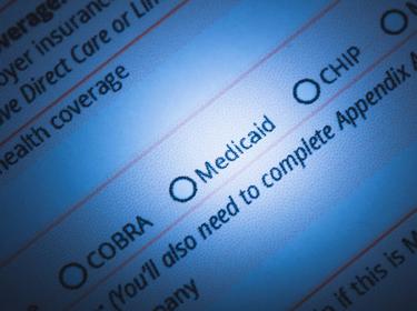 A stock photo of a health insurance application form focused on the word, "Medicaid," photo by LPETTET/Getty Images