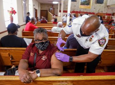 A woman receives a COVID-19 vaccine from a paramedic at the historic Greater Bethel Missionary Baptist Church in Tampa, Florida, February 14, 2021, photo by Octavio Jones/Reuters