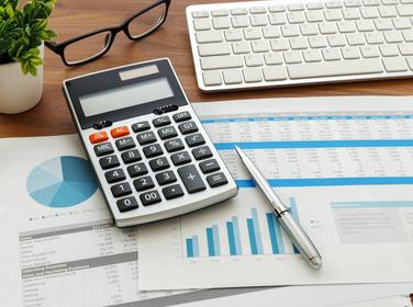 Financial accounting with calculator and financial data, photo by thanksforbuying/AdobeStock
