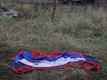A Russian flag lies on the ground near a destroyed Russian tank in the town of Izium, which was liberated by Ukrainian Armed Forces in the Battle of Kharkiv, Ukraine, September 14, 2022, photo by Gleb Garanich/Reuters