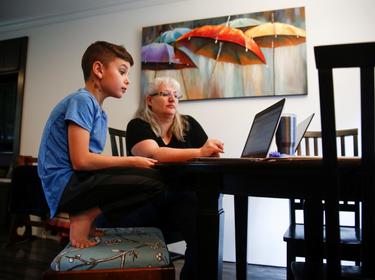 Chrissy Brackett and grandson Caidence Miller learn to navigate an online learning system at her home in Woodinville, Washington, March 11, 2020, photo by Lindsey Wasson/Reuters