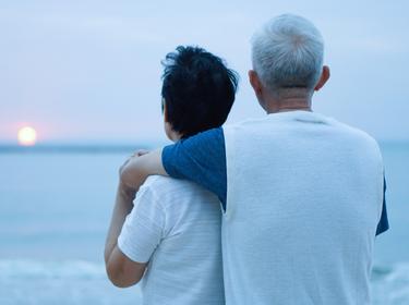 Asian senior man and woman at the beach at sunrise, photo by glowonconcept/Getty Images