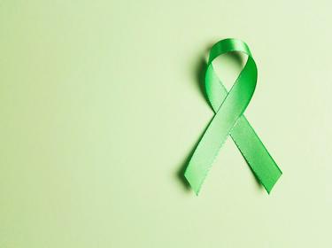 World mental health day concept with a green awareness ribbon, photo by WindyNight/AdobeStock