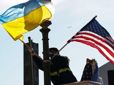 A worker installs Ukrainian and U.S. flags along Pennsylvania Avenue ahead of a visit by Ukraine's President Volodymyr Zelenskyy, Washington, D.C., December 21, 2022, photo by Kevin Lamarque/Reuters