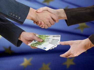 Close up of two hands shaking while two other hands exchange euro banknotes, photo by Jakub Danek/Adobe Stock