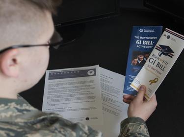 Airman Dalton Shank, 5th Bomb Wing public affairs specialist, reads pamphlets on the Montgomery GI Bill and the Post-9/11 GI Bill at Minot Air Force Base, N.D., March 10, 2017, photo by Airman 1st Class Alyssa Akers/National Guard 