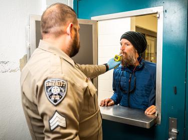 A deputy administers a breath test for alcohol during a 24/7 Sobriety program morning check-in in Utah, May 24, 2022, photo courtesy of the Utah Department of Public Safety