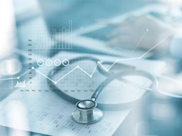 Healthcare business graph and medical examination, with stethoscope and businessman in blurred background, photo by ipopba/Adobe Stock