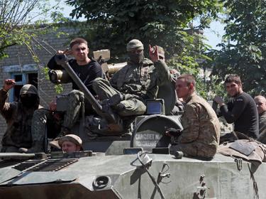 Service members of pro-Russian troops ride an armoured vehicle in the town of Popasna in the Luhansk Region, Ukraine, June 2, 2022, photo by Alexander Ermochenko/Reuters